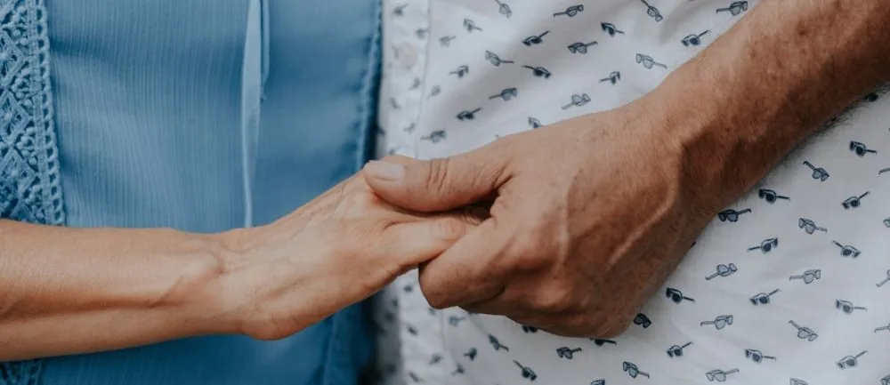 Main d’un proche tenant celle d’une personne âgée