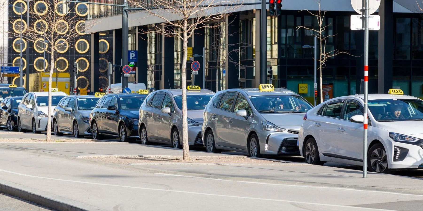 File de taxis en station devant des immeubles modernes